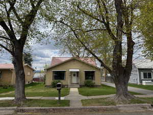 Bungalow-style home with entry steps and a front lawn