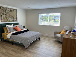 Bedroom with baseboards, recessed lighting, and light wood-style flooring