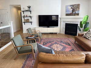 Living room featuring baseboards, a glass covered fireplace, and wood finished floors