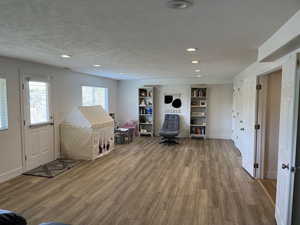 Game room with recessed lighting, baseboards, wood finished floors, and a textured ceiling