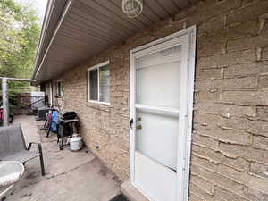 Entrance to property featuring central air condition unit and a patio area