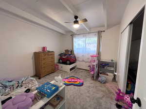 Bedroom featuring ceiling fan, carpet flooring, and beam ceiling