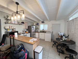Kitchen with washer / clothes dryer, open shelves, appliances with stainless steel finishes, and plenty of natural light