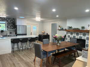 Dining room with recessed lighting, ornamental molding, and light wood-style flooring