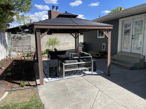 View of patio, French doors, a gazebo, fence, outdoor lounge area, and entry steps