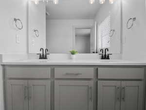 The primary suite offers this upgraded dual vanity with quartz countertops and tons of storage.