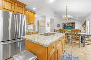 Granite countertops, stainless steel appliances, tile flooring and a center island