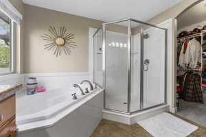 Primary suite private bath with oversized garden soaking tub and separate shower