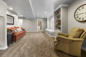 Basement family room with built in bookshelves, window seat, and fresh paint