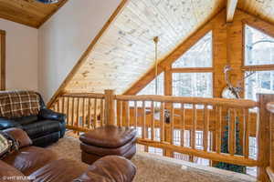 Living area featuring high vaulted ceiling and wooden ceiling