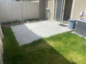 View of patio / terrace featuring a garden, central air condition unit, and fence