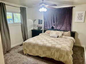 Carpeted bedroom with baseboards and ceiling fan