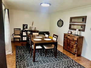 Dining area with baseboards, ornamental molding, and wood finished floors