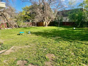 View of yard with a storage shed, an outbuilding, and a fenced backyard
