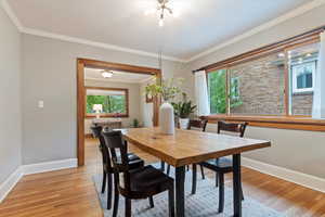 Dining area with baseboards, a wealth of natural light, and light wood-type flooring