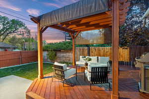 Wooden terrace with a fenced backyard, an outdoor hangout area, and a yard