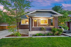 Bungalow featuring a yard, a porch, and brick siding