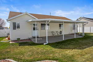 Rear view of house featuring fence, a gate, a patio area, and a yard