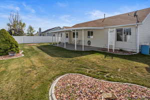 View of back yard with fence and a patio