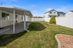 View of back yard with a patio and a fence.