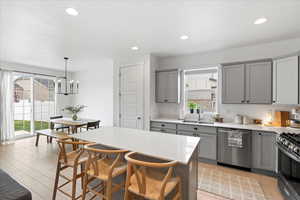 Kitchen featuring large island, upgraded cabinets and countertops, stainless steel appliances, gas range, and pantry.
