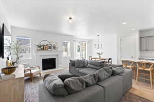 Spacious open concept living room with upgraded fireplace/mantel, large windows, and room for a lot of seating.