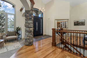 Entrance foyer featuring baseboards, decorative columns, a towering ceiling, and a notable chandelier