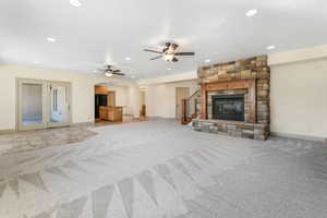 Unfurnished living room with light colored carpet, arched walkways, ceiling fan, and recessed lighting