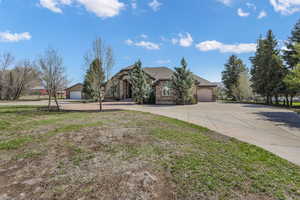 View of front of home with an attached garage, driveway, and a front yard