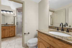 Full bathroom with a sink, tile patterned flooring, a shower stall, and two vanities