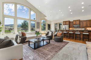 Living area with recessed lighting, a mountain view, high vaulted ceiling, and light wood-type flooring