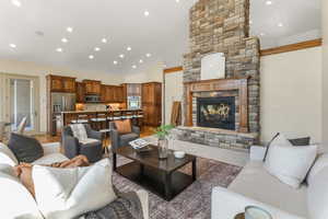 Living room with recessed lighting, high vaulted ceiling, and a stone fireplace