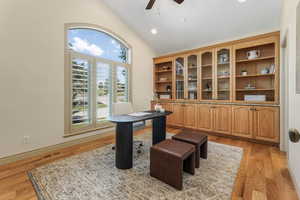 Home office with high vaulted ceiling, a ceiling fan, light wood-style flooring, and visible vents