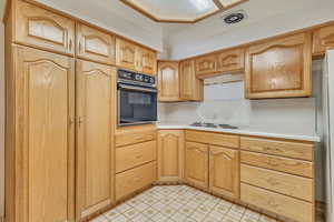 Kitchen featuring light countertops, black oven,  and white electric cooktop