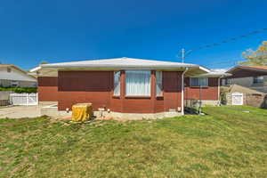 View of home's exterior featuring fence, a yard, and brick siding