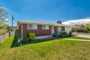 View of front of property with an attached garage, fence, brick siding, and concrete driveway