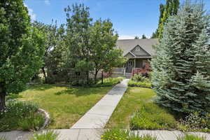 Obstructed view of property with a front yard and a porch