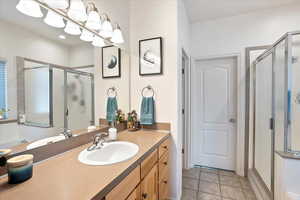 Full bathroom featuring tile patterned floors, vanity, and a stall shower