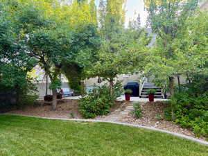 View of grassy yard featuring stairway