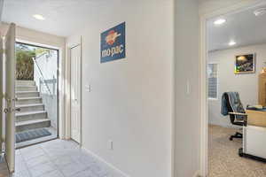 Interior space featuring recessed lighting, stairs, a textured ceiling, and baseboards
