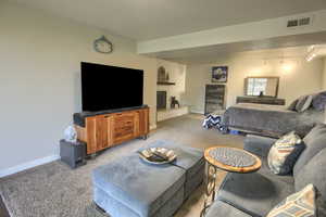 Bedroom featuring baseboards,  light carpet, and a fireplace