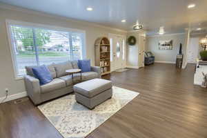 Living area featuring crown molding, baseboards, and plenty of natural light