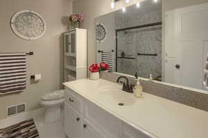 Bathroom with vanity, toilet, baseboards, and a walk in shower stall
