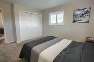 Bedroom with a closet, carpet, and baseboards