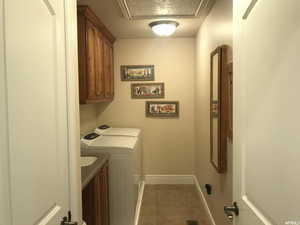 Clothes washing area with baseboards, cabinet space, light tile patterned floors, and washing machine and dryer
