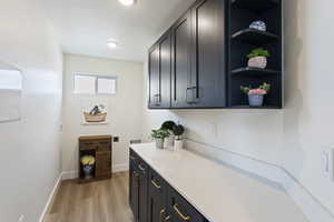 Bar featuring recessed lighting, a textured ceiling, baseboards, and light wood-style floors