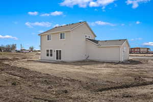 Rear view of house with a shingled roof and stucco siding