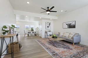 Living room with recessed lighting, baseboards, ceiling fan, and light wood-style floors