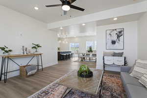 Living area featuring a ceiling fan, baseboards, recessed lighting, and light wood finished floors