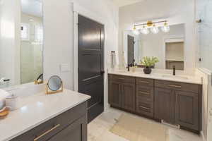 Bathroom with visible vents, a sink, marble finish floor, and double vanity